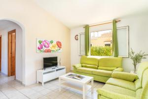 a living room with a couch and a tv at Villa Luna by Villa Plus in Cala'n Bosch