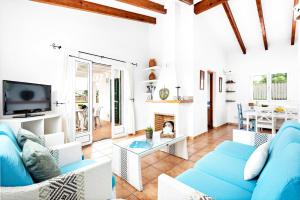 a living room with a blue couch and a fireplace at Villa Bini Anna by Villa Plus in Binibeca