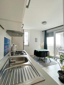 uma cozinha com um lavatório, um fogão e uma mesa em Apartman Milla em Makarska