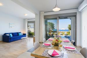 jadalnia ze stołem i niebieską kanapą w obiekcie Villa Rhodes Sea View II by Villa Plus w miejscowości Ixiá