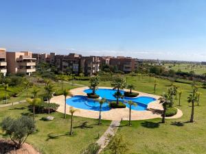 an overhead view of a pool with palm trees and buildings at Prestigia jade Marrakech ENTREE 191 APPARTEMENT 9 in Marrakesh