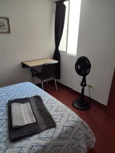 1 dormitorio con 1 cama, escritorio y ventilador en Habitación privada con vista a la ciudad en Pereira