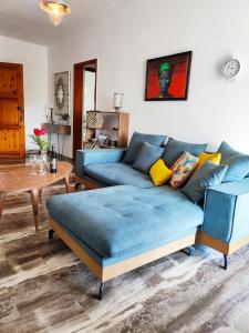 a living room with a blue couch and a table at Lauren's Charm Town Apartment in Lefkada