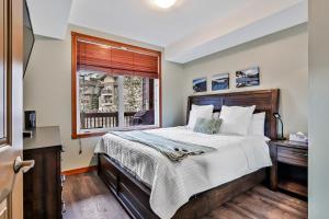 una camera con un grande letto e una finestra di Fenwick Vacation Rentals Inviting Rocky Mountain HOT TUB in Top Rated Condo a Canmore