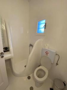 uma casa de banho branca com um WC e uma banheira em Fabrica Sunset Apartments em Megali Ammos