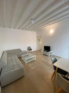 a large living room with a couch and a tv at Fabrica Sunset Apartments in Megali Ammos