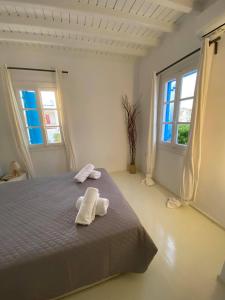 a bedroom with a bed with two towels on it at Fabrica Sunset Apartments in Megali Ammos