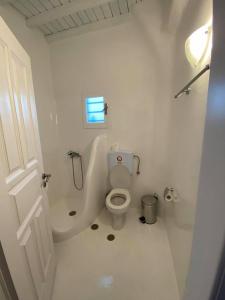 a white bathroom with a toilet and a sink at Fabrica Sunset Apartments in Megali Ammos