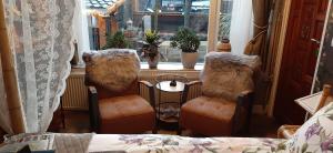 Zimmer mit 2 Stühlen, einem Tisch und einem Fenster in der Unterkunft B&B de Hartewens in Zuidland