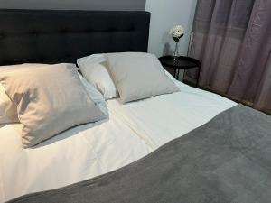a bed with white sheets and pillows on it at Przystanek Sopot Plaża in Sopot