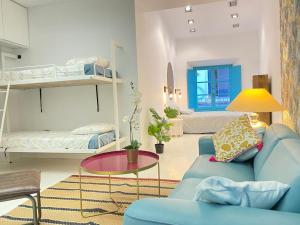 een woonkamer met een blauwe bank en een bed bij Apartamentos Giralda, centro Histórico Sevilla in Sevilla