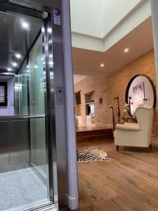 een woonkamer met een stoel en een spiegel bij Apartamentos Giralda, centro Histórico Sevilla in Sevilla