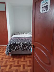 Zimmer mit einem Bett und einem Schild an der Tür in der Unterkunft HOSTAL EL CARIBE in Ayacucho