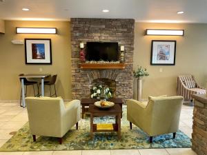 a living room with two chairs and a fireplace at SureStay Plus Hotel by Best Western Buckhannon in Buckhannon