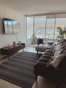 a living room with a couch and a large window at Pleno centro de iquique in Iquique