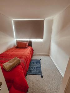 a small bedroom with a red bed in a room at Pleno centro de iquique in Iquique