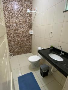 uma casa de banho com um WC, um lavatório e um chuveiro em Apuama Hostel em Ubajara