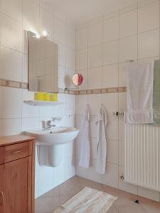 a white bathroom with a sink and a mirror at 4 Kreuzstraße Laaschhof in Nusbaum