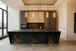 a kitchen with a black island and two stools at Sonder Onyx in Philadelphia