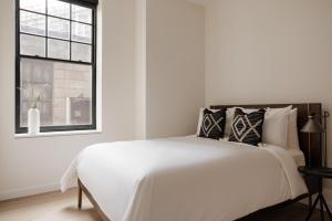 a white bedroom with a large bed and a window at Sonder Onyx in Philadelphia