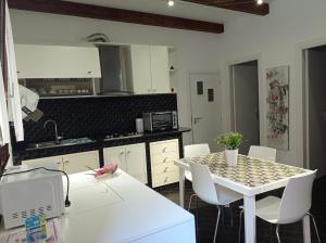 een keuken met een witte tafel en witte stoelen bij Casa Balestrate in Balestrate