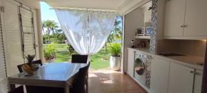 cocina con mesa y vistas al patio en La Perle des Caraïbes en Sainte-Anne