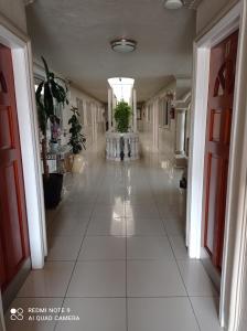 un corridoio con un grande pavimento piastrellato bianco in un edificio di Suites Leon Rojo a Tijuana