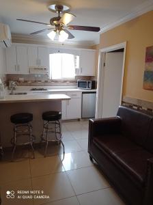 Suites Leon Rojo في تيخوانا: غرفة معيشة مع أريكة ومطبخ