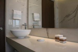 a bathroom with a sink and a large mirror at Beach Front Renewed Apartment in Cancún