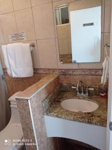 bagno con lavandino, specchio e servizi igienici di Suites Leon Rojo a Tijuana