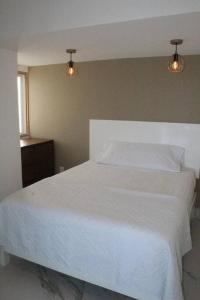 sypialnia z białym łóżkiem z dwoma światłami w obiekcie Beach Front Renewed Apartment w mieście Cancún