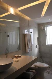 W łazience znajduje się umywalka, toaleta i lustro. w obiekcie Beach Front Renewed Apartment w mieście Cancún