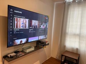 TV de pantalla plana colgada en la pared en The Cozy Place Condo in Pasig Phil, en Manila