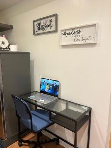 a glass desk with a laptop computer on it at The Cozy Place Condo in Pasig Phil in Manila