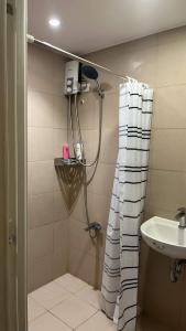 een badkamer met een douche en een wastafel bij The Cozy Place Condo in Pasig Phil in Manilla