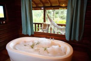 bañera con nieve frente a una ventana en Cabanas Cambuim - Urubici - SC, en Urubici