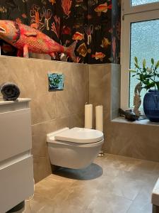 ein Badezimmer mit einem WC und einer Fischtapete in der Unterkunft Luxus Altbaucharme in zentraler Lage in Kiel
