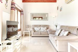 ein Wohnzimmer mit 2 Sofas und einem TV in der Unterkunft Villa Casa de Pedra by Villa Plus in Crestatx