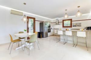 eine Küche und ein Esszimmer mit einem Tisch und Stühlen in der Unterkunft Villa Casa de Pedra by Villa Plus in Crestatx