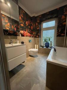a bathroom with a sink and a tub and a toilet at Luxus Altbaucharme in zentraler Lage in Kiel