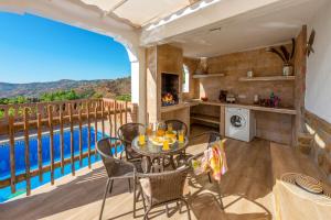 une terrasse avec une table, des chaises et une piscine dans l'établissement Villa Piedras Blancas by Villa Plus, à Frigiliana