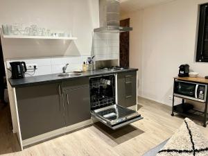a kitchen with a stove and a sink in it at Holiday Home Maridu Wellness in Arnhem