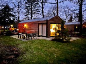 een kleine hut met een picknicktafel in een tuin bij Holiday Home Maridu Wellness in Arnhem