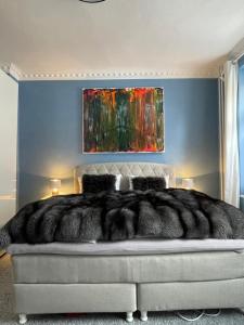 a bedroom with a bed with a painting on the wall at Luxus Altbaucharme in zentraler Lage in Kiel