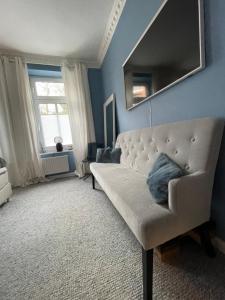 a living room with a couch and a mirror at Luxus Altbaucharme in zentraler Lage in Kiel