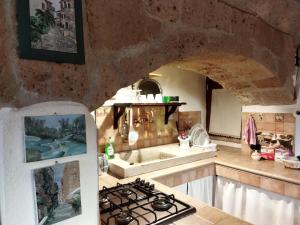 a kitchen with a sink and a stove top oven at Romantic loft in Pitigliano