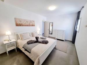biała sypialnia z dużym łóżkiem i komodą w obiekcie Luxury Villa Zen w Puerto del Carmen +23 zdjęcia