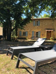 un grupo de mesas de picnic frente a un edificio en Mas Boudeissoun - Cœur de cerise - Baignade à 600 m, en Mormoiron