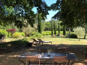 una mesa de picnic y bancos en un parque en Mas Boudeissoun - Cœur de cerise - Baignade à 600 m, en Mormoiron