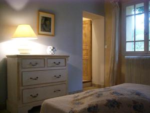 a bedroom with a dresser with a lamp on it at Mas Boudeissoun - Cœur de cerise - Baignade à 600 m in Mormoiron